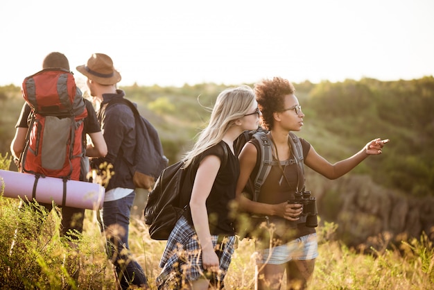 Jóvenes amigos con mochilas disfrutando de la vista, viajando en el cañón