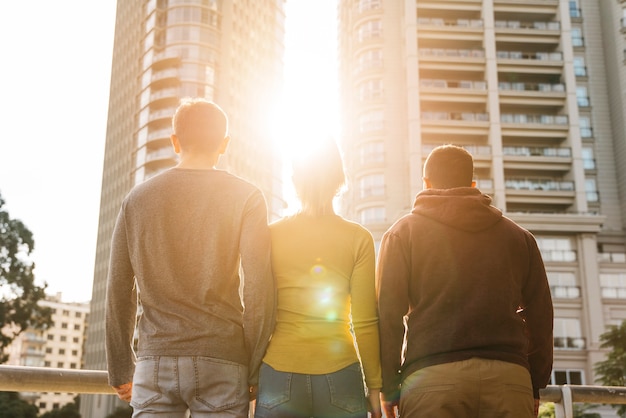 Jóvenes amigos de pie y mirando la puesta de sol