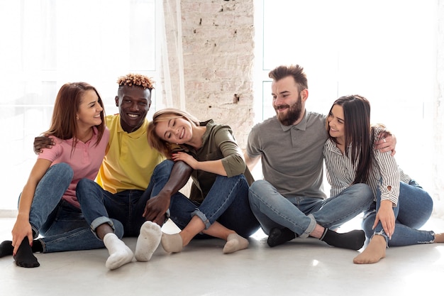 Jóvenes amigos sentados juntos en el piso