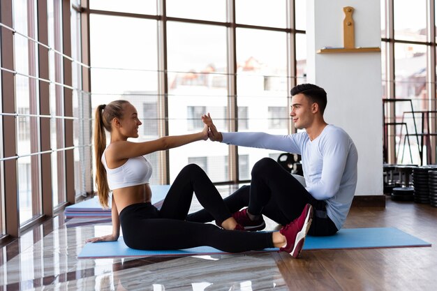 Jóvenes amigos trabajando juntos en la clase de fitness