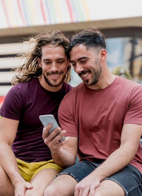 Jóvenes amigos varones mirando móvil