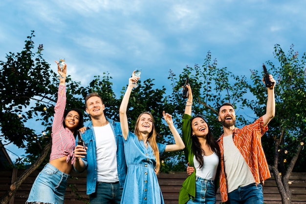 Foto gratuita jóvenes de ángulo bajo celebrando la amistad