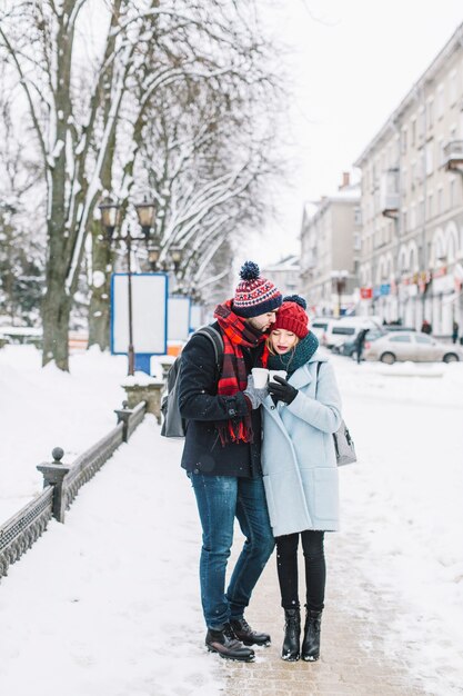 Jóvenes apacibles que abrazan en la ciudad de invierno