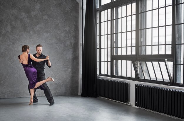 Jóvenes bailando tango en un estudio.