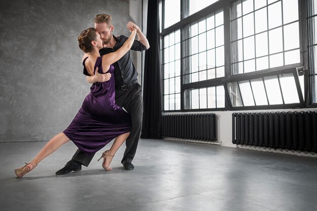 Jóvenes bailando tango en un estudio.