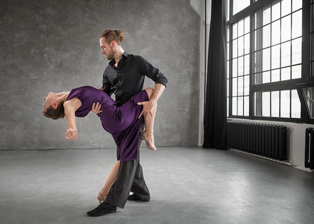 Jóvenes bailando tango en un estudio.