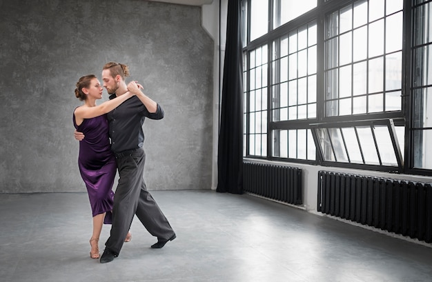 Jóvenes bailando tango en un estudio.