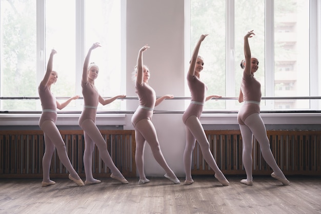 Jóvenes bailarinas de ballet femenino agraciado bailando en la formación. Belleza del ballet clásico.