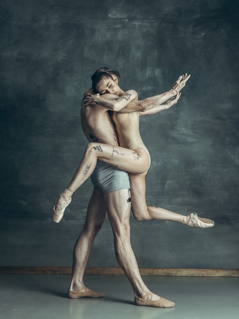 jóvenes bailarines de ballet moderno posando en gris