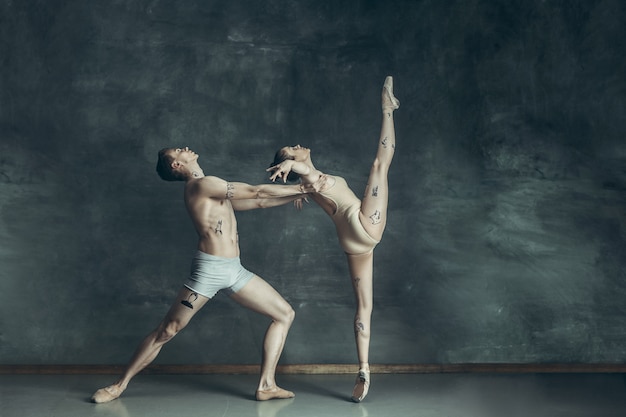 jóvenes bailarines de ballet moderno posando en gris