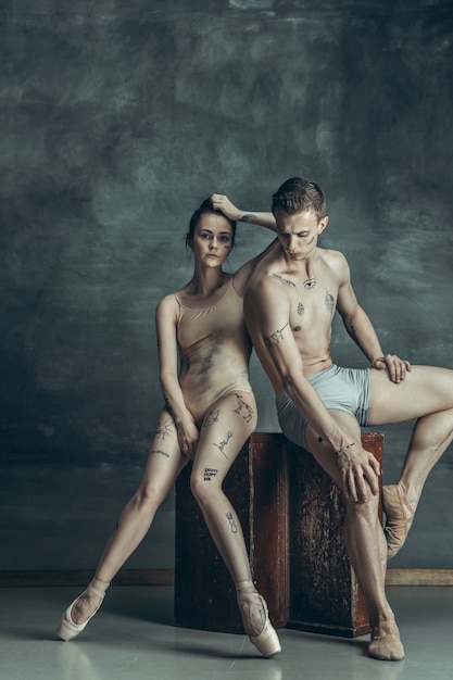 Foto gratuita jóvenes bailarines de ballet moderno posando en gris
