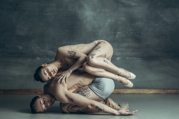 jóvenes bailarines de ballet moderno posando en gris