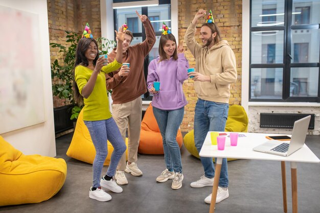 Jóvenes celebrando en la oficina y luciendo felices y disfrutados.