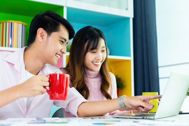 Jóvenes colegas bebiendo bebidas durante el trabajo