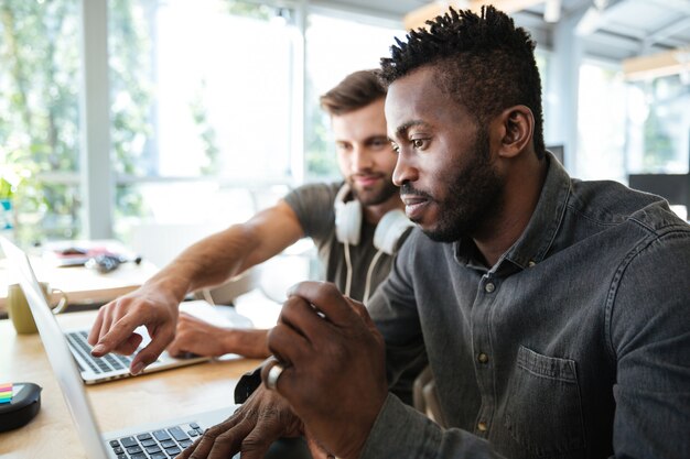 Jóvenes colegas concentrados sentados en la oficina de coworking