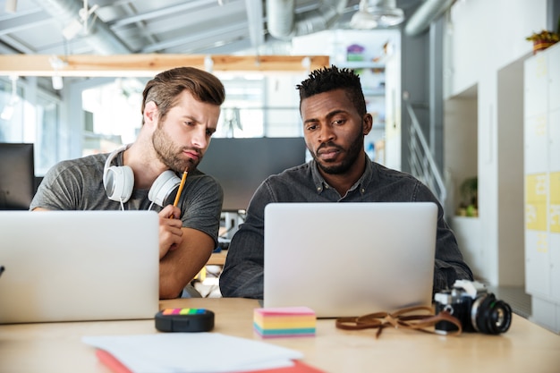 Jóvenes colegas concentrados sentados en la oficina de coworking