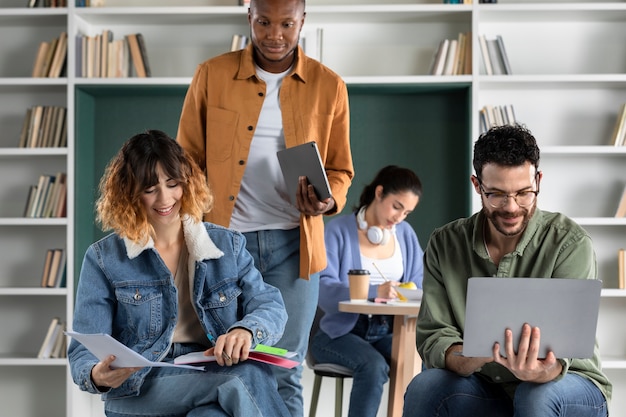 Jóvenes colegas que estudian desde una computadora portátil y una computadora portátil durante la sesión de estudio