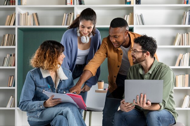 Jóvenes colegas que estudian desde una computadora portátil y una computadora portátil durante la sesión de estudio