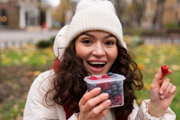 Foto gratuita jóvenes comiendo bayas en la calle