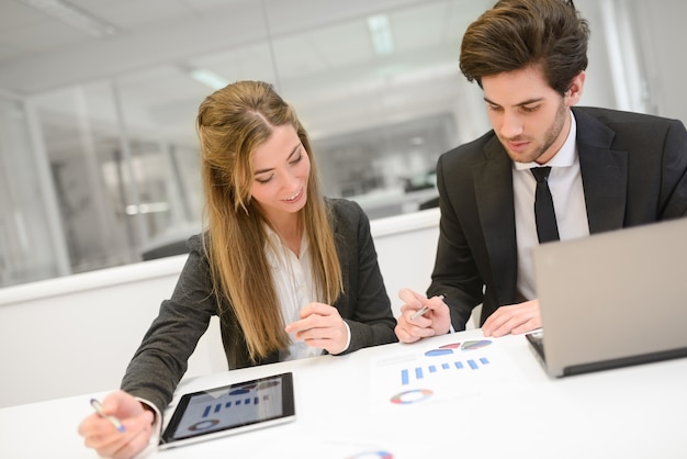 Jóvenes compañeros trabajando juntos en la gráfica