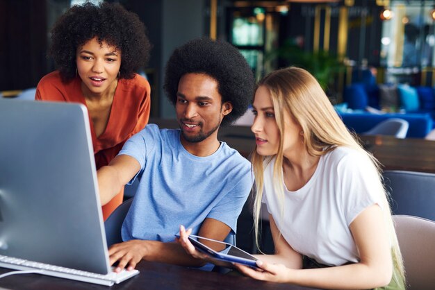 Jóvenes compañeros de trabajo que trabajan en la computadora en la oficina