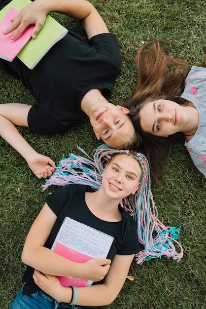 Foto gratuita jóvenes con cuadernos sobre hierba