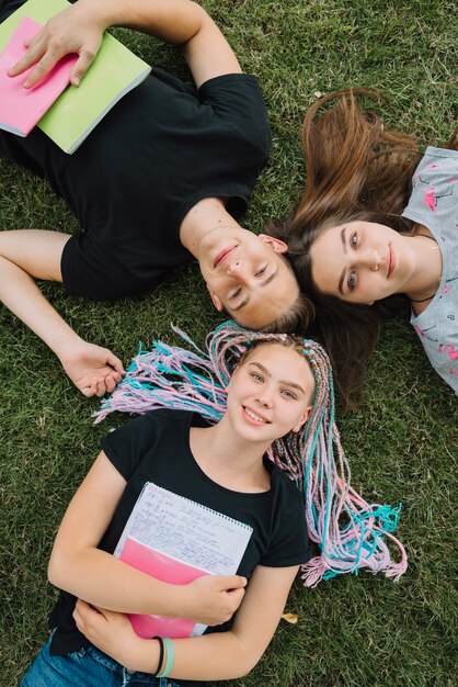 Jóvenes con cuadernos sobre hierba