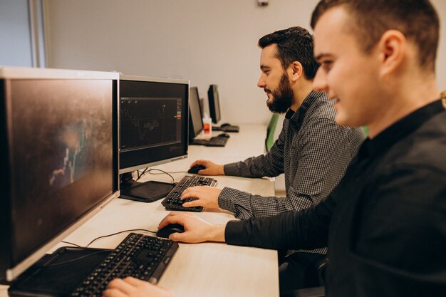 Jóvenes diseñadores web masculinos que trabajan en una computadora