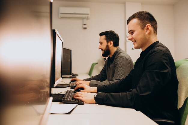 Jóvenes diseñadores web masculinos que trabajan en una computadora