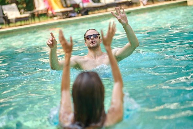 Jóvenes divirtiéndose y disfrutando en la piscina.