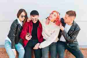 Foto gratuita jóvenes divirtiéndose mientras toman selfie en smartphone