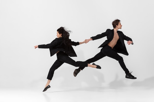 Jóvenes y elegantes bailarines de ballet en estilo minimalista negro aislado en blanco