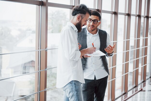 Jóvenes empresarios están discutiendo nuevas ideas creativas juntos durante una reunión en la oficina