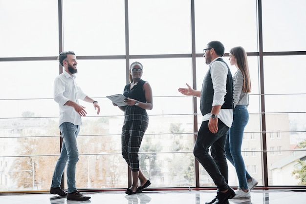 Jóvenes empresarios están discutiendo nuevas ideas creativas juntos durante una reunión en la oficina