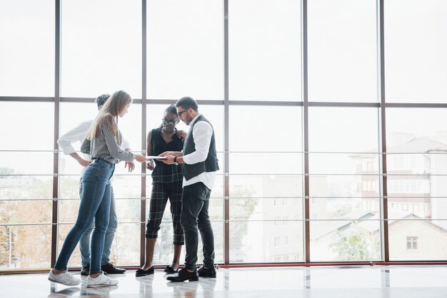 Jóvenes empresarios están discutiendo nuevas ideas creativas juntos durante una reunión en la oficina