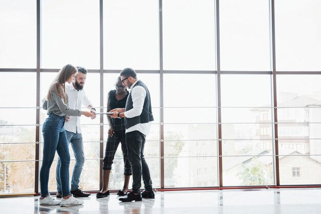 Jóvenes empresarios están discutiendo nuevas ideas creativas juntos durante una reunión en la oficina