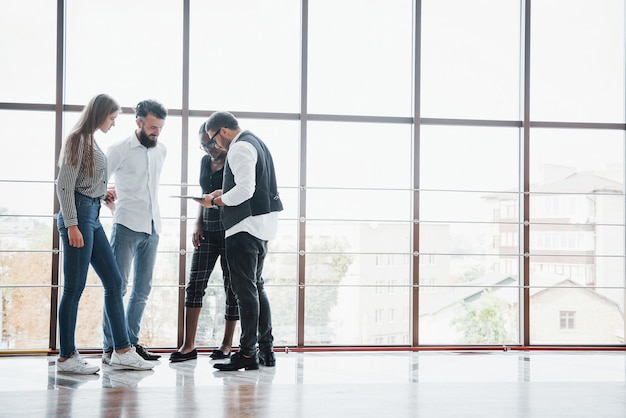 Jóvenes empresarios están discutiendo nuevas ideas creativas juntos durante una reunión en la oficina