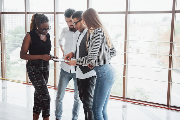 Jóvenes empresarios están discutiendo nuevas ideas creativas juntos durante una reunión en la oficina