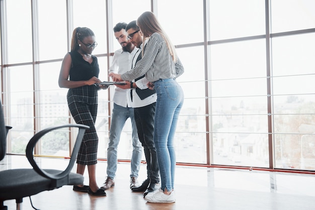 Jóvenes empresarios están discutiendo nuevas ideas creativas juntos durante una reunión en la oficina