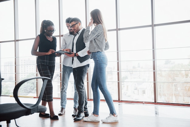 Jóvenes empresarios están discutiendo nuevas ideas creativas juntos durante una reunión en la oficina