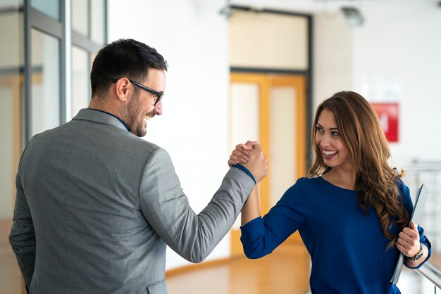 Jóvenes empresarios exitosos saludando en la oficina de la empresa