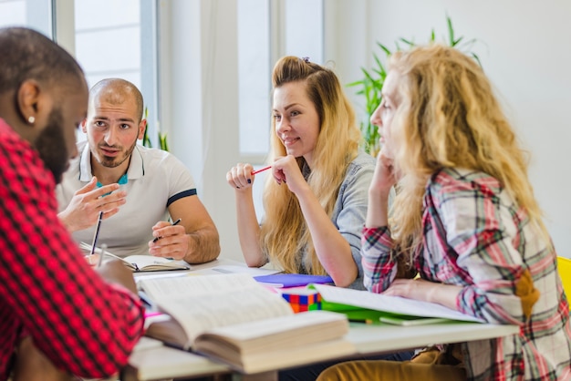 Foto gratuita jóvenes estudiando juntos en una mesa