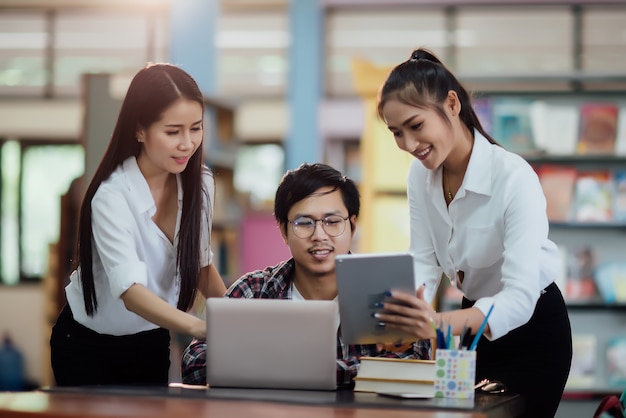 Jóvenes estudiantes aprendiendo, bibliotecas de estanterías.