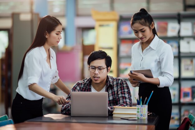 Jóvenes estudiantes aprendiendo, bibliotecas de estanterías.