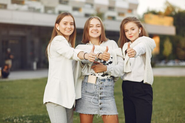 Jóvenes estudiantes en un campus de estudiantes mostrando los pulgares para arriba