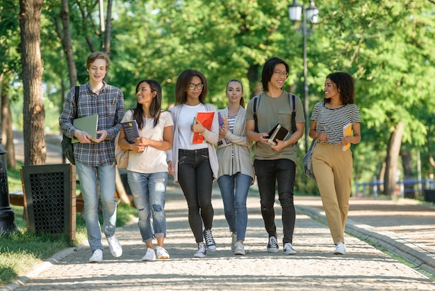 Jóvenes estudiantes felices caminando mientras habla