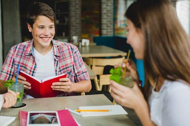 Foto gratuita jóvenes estudiantes con libros en el café