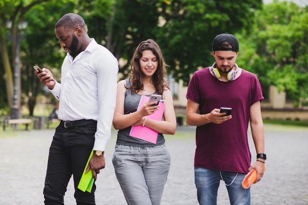 Foto gratuita jóvenes estudiantes con teléfonos inteligentes