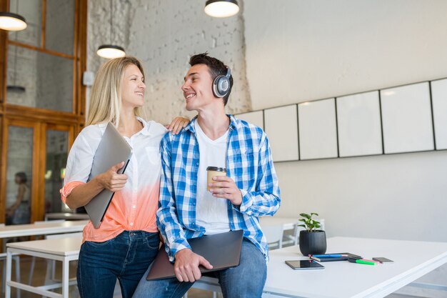 Jóvenes felices con estilo en la oficina de coworking,