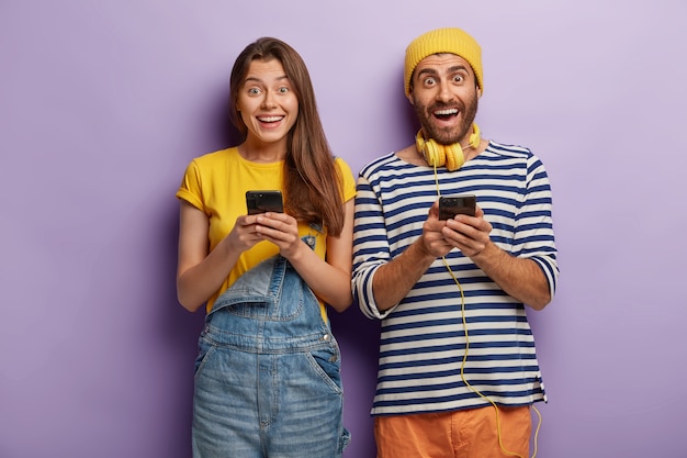 Los jóvenes felices y llenos de alegría envían mensajes de texto, adictos a las tecnologías modernas